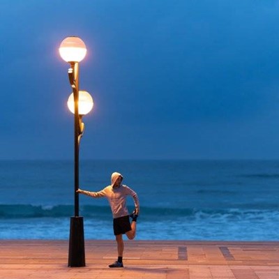JOGGER, SHORTS, OCEAN, WAVES, EXERCISE, STRETCHING, SNEAKERS, SOCKS, HOOD, STREETLIGHT, PAVING