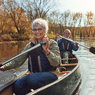 LIFEJACKET, JEANS, BRACELET, PADDLE, ROWING, SMILE, ACTIVE, RIVER, COAT, GLASSES, TREES, BOAT