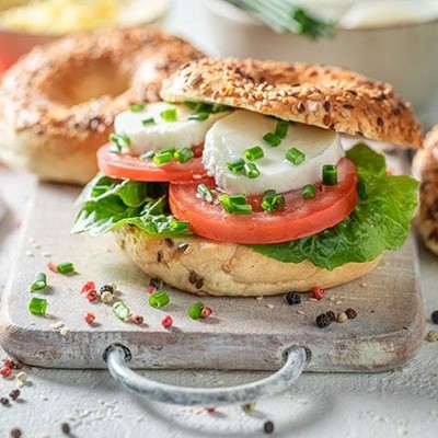 BAGEL, BREAD, SEEDED, TOMATO, CHIVES, SLICED, BOARD, SNACK, LETTUCE, MOZZARELLA, PEPPERCORNS