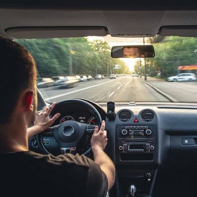 DRIVING, MIRROR, CAR, SIDEWALK, WINDSHIELD, BUTTONS, WHEEL, RADIO, INTERIOR, ROAD, REFLECTION